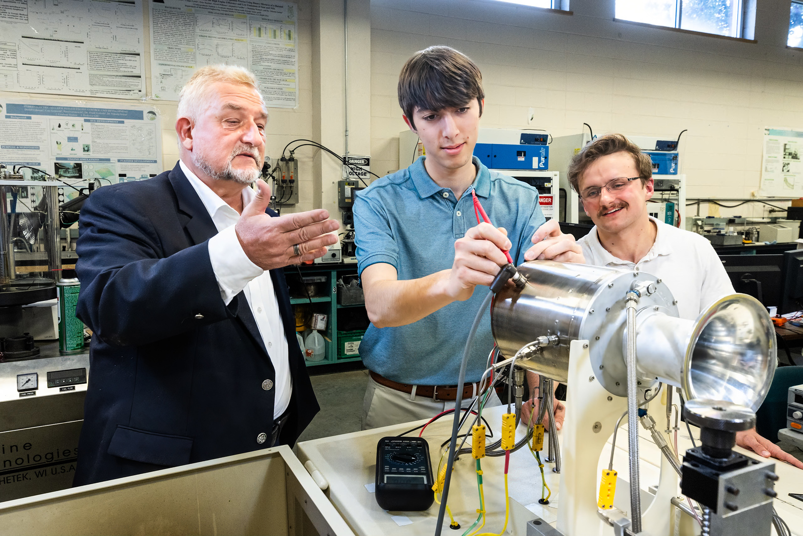 An instructor and students observing electrical current and power during an experiment.