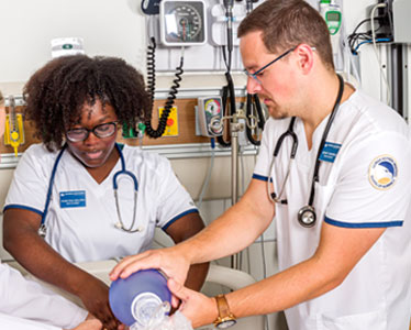 Two students from Georgia Southern's Accelerated BSN program practice patient care techniques in a clinical simulation space.