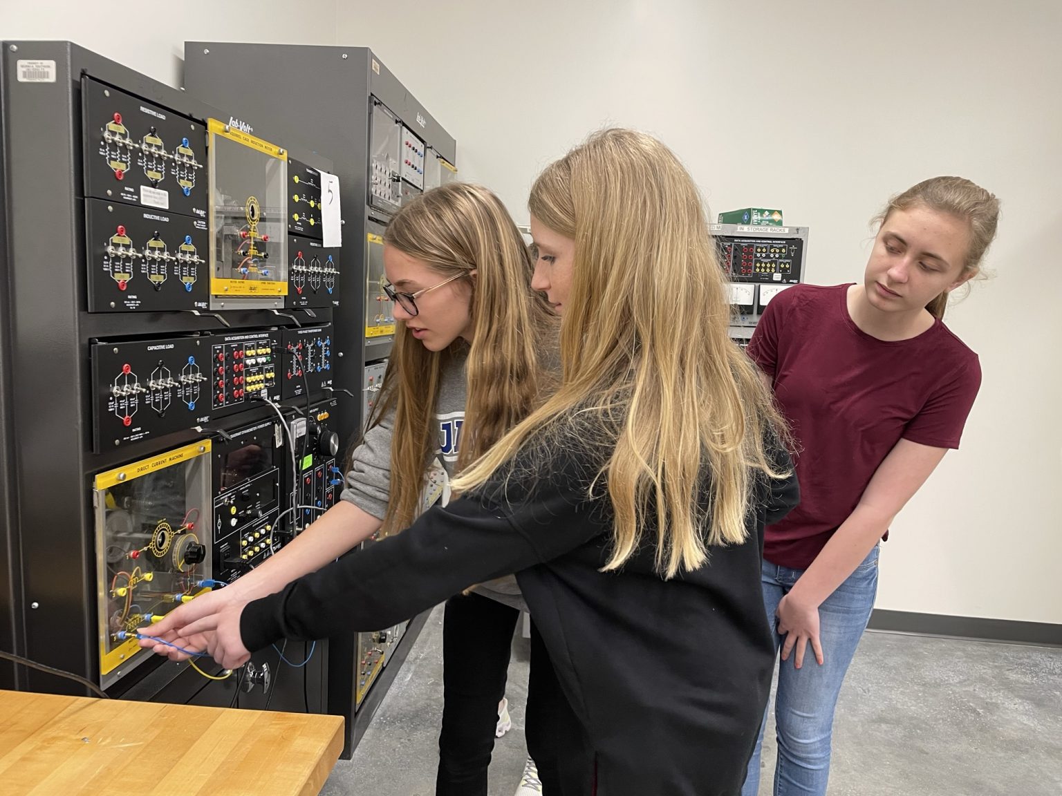 Three female students working together on circuit boards for electrical and computer engineering.
