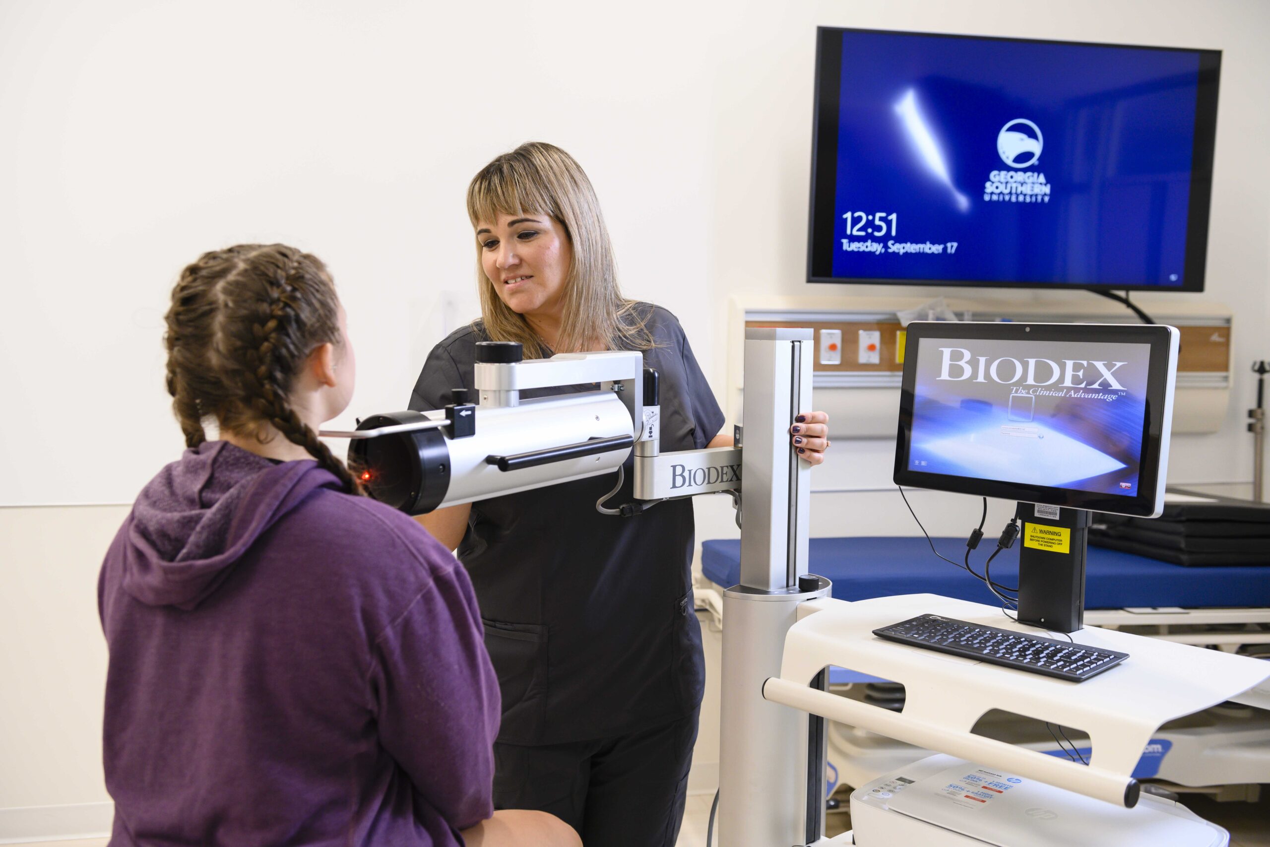 A Georgia Southern student nuclear medicine technologist operating advanced imaging equipment while working one of one with a professional.