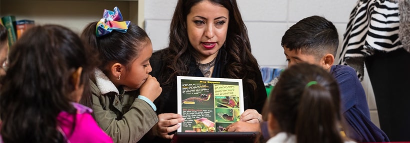 A female educator holding up an educational sheet about carnivorous plants (