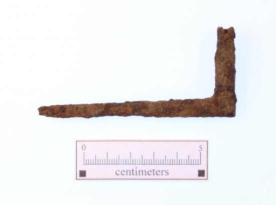 A rusted metal object shaped like the letter L, about 8 centimeters long.