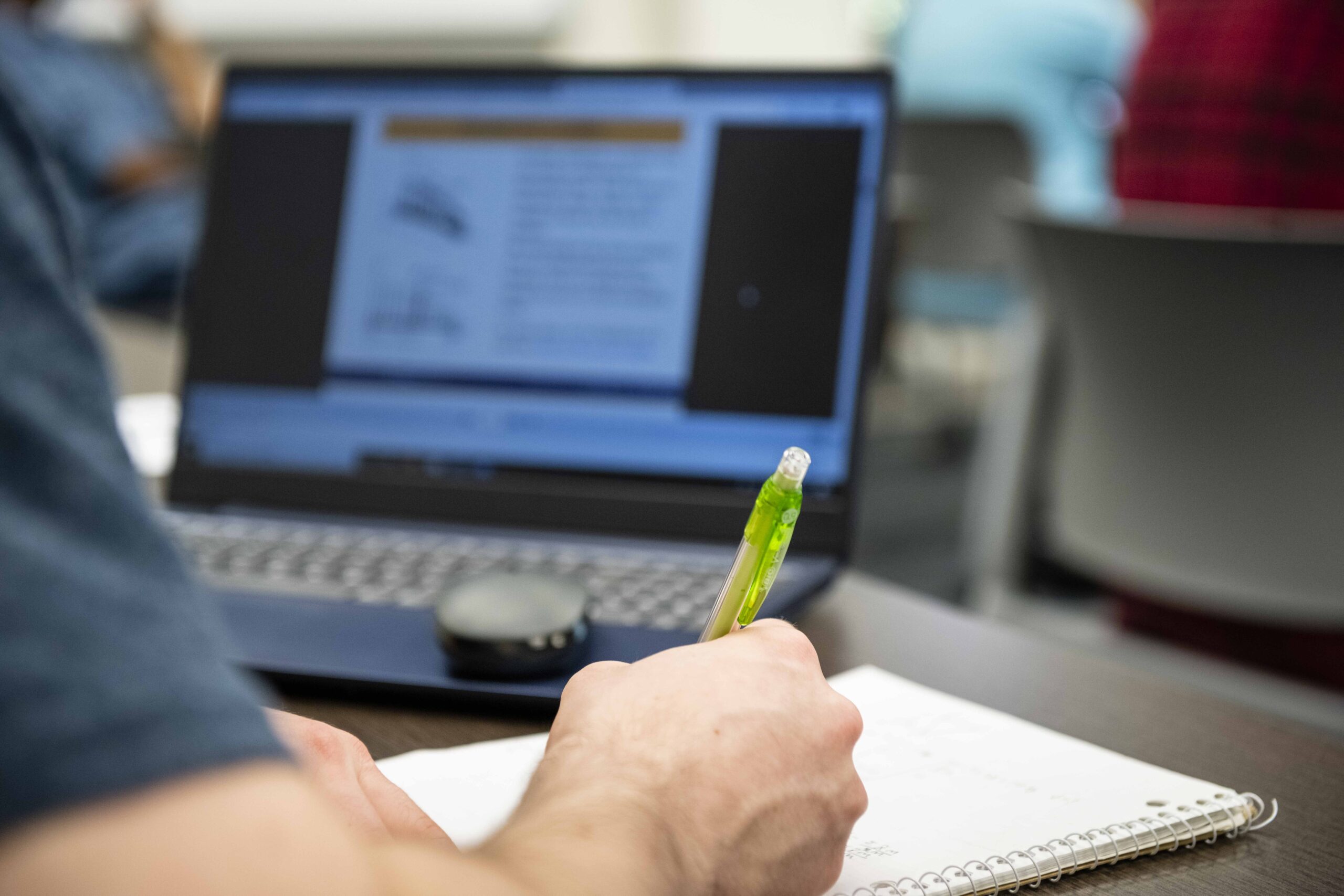 Student taking notes from a computer