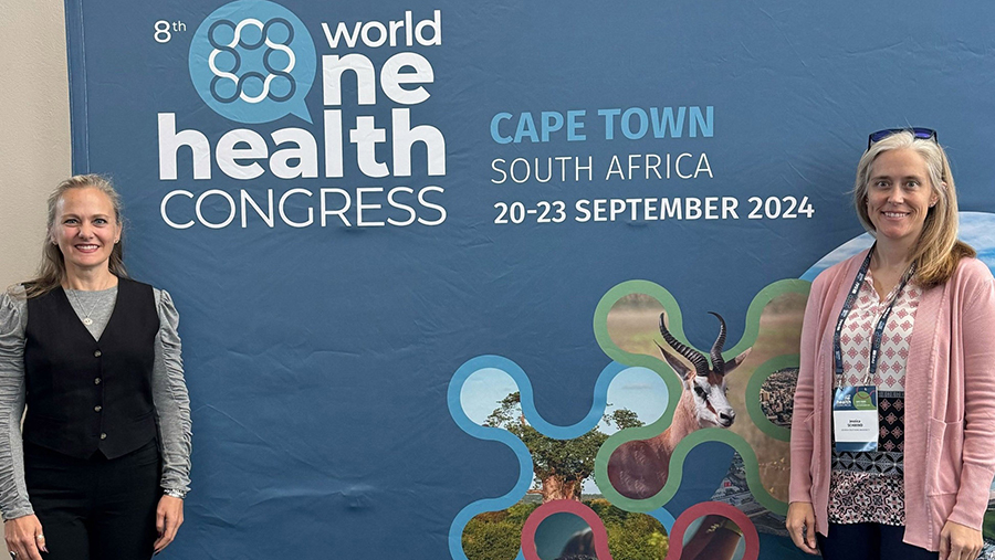 Two women pose in front of a blue World Health Congress banner that reads 'Cape Town, South Africa, 20–23 September 2024'.