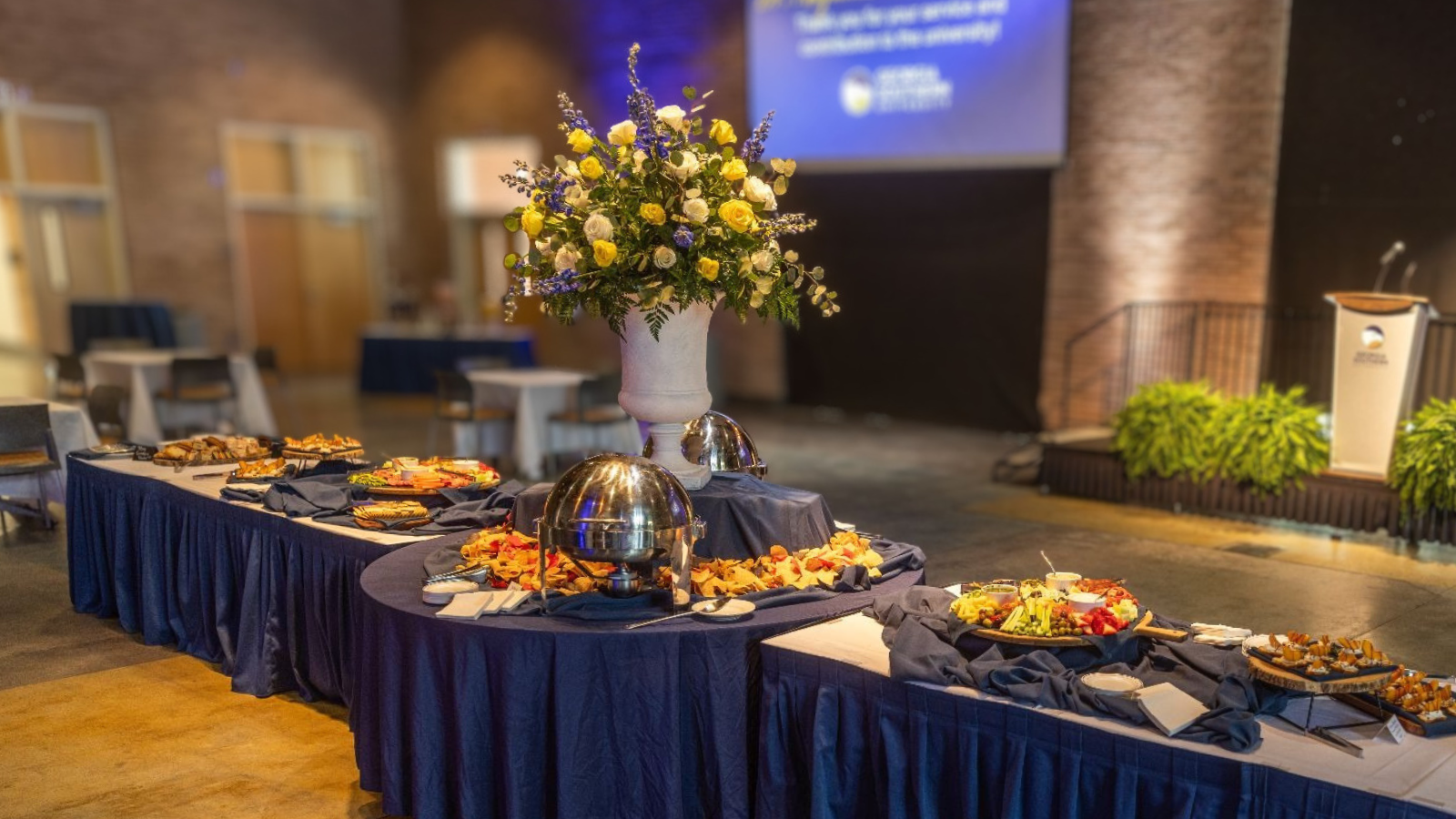 A picture of a catered food spread with decorative center piece.